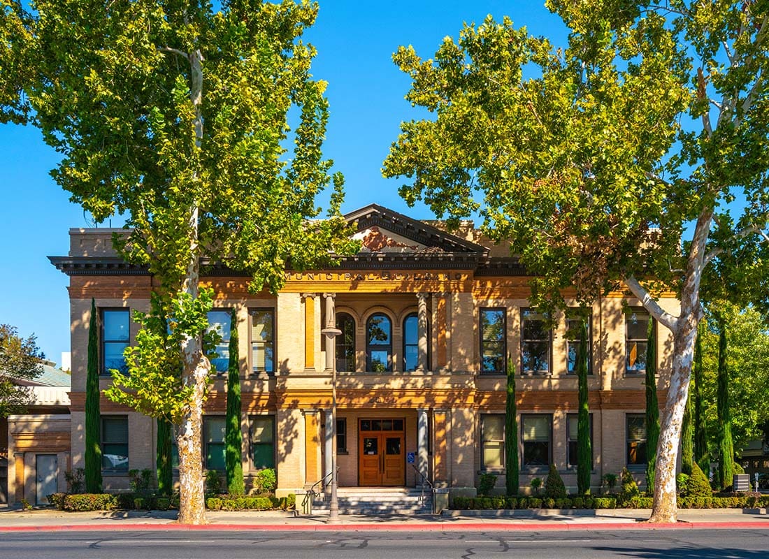 Chico, CA - Exterior View of the City Town Hall in Downtown Chico California Against a Clear Blue Sky with Green Trees in the Front