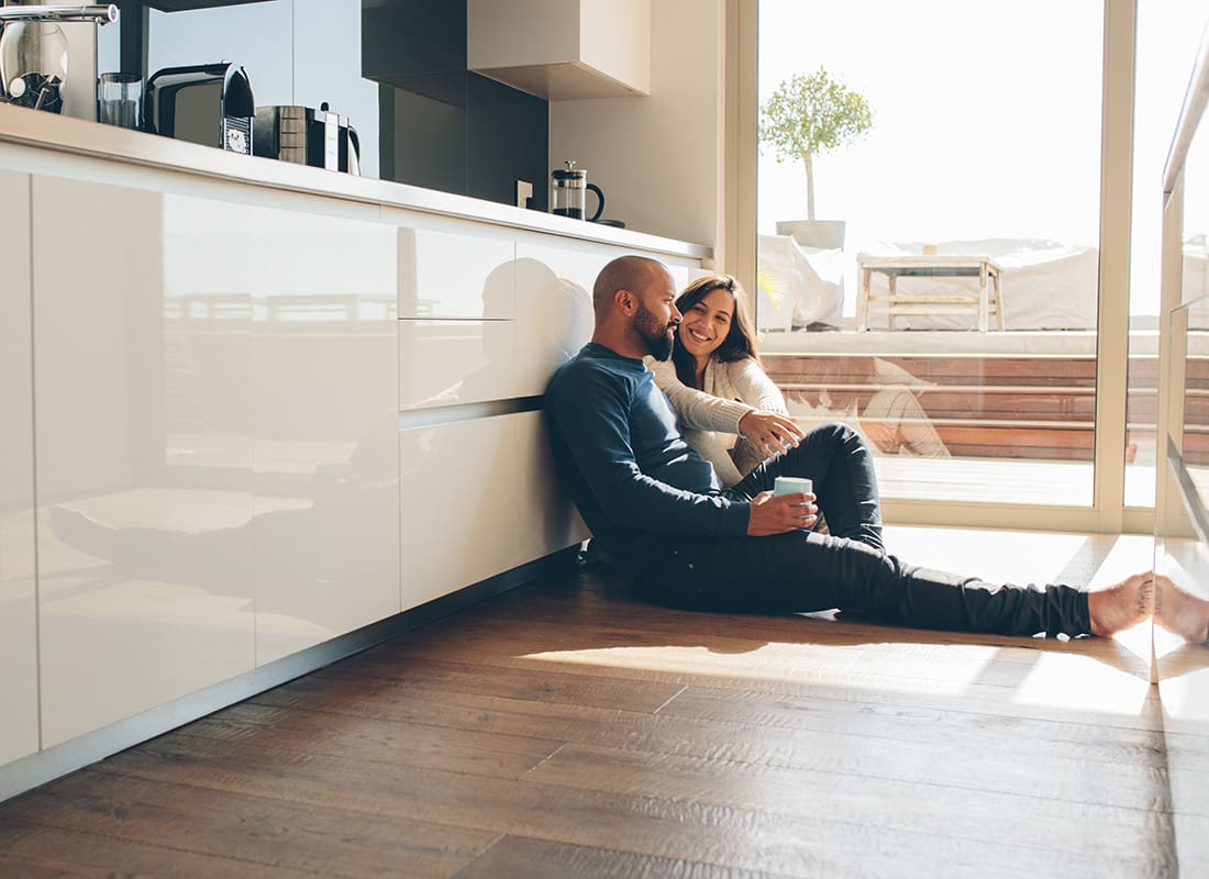 Personal Insurance - View of a Young Couple Sitting on the Floor in the Kitchen in Their Modern Home